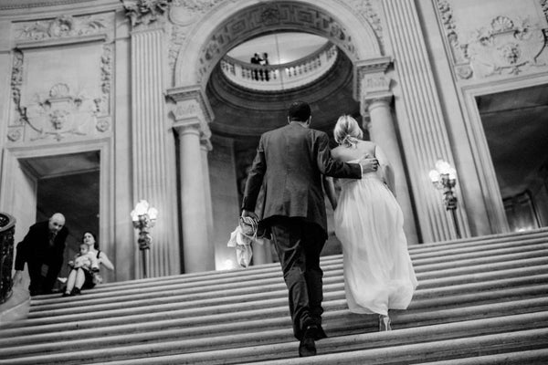 ウェディングドレスとタキシードを着た男女の後ろ姿