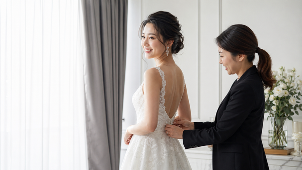 ウェディングドレスのサイズ調整をするスタッフと花嫁